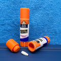 "Birch Bond" variant of the Velcro Dog's Super Cured Scent Glue Hide.  This fun training aid includes an orange squeeze tube with a custom label.  Shown with the cap off and a small Q-tip on a blue textured background.